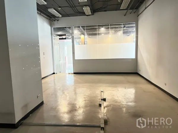 Retail Space for rent - Open-plan 49 sqm shop interior with glass frontage, polished floor and exposed ceiling lighting.