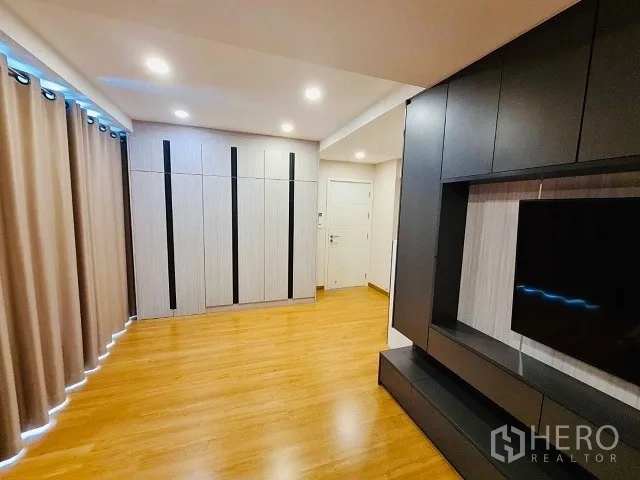 Detached House for sale in Suan Luang, Bangkok - Multipurpose bedroom with built‑in wardrobes, TV wall unit, recessed lights, and wood floors.