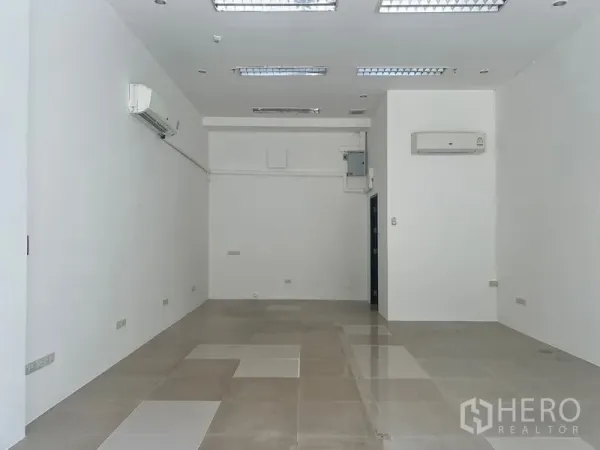 Retail Space for rent in Khlong Toei, Bangkok - Open-plan retail space showing high ceiling lights, glossy tiles, and utility panel for easy fit-out.