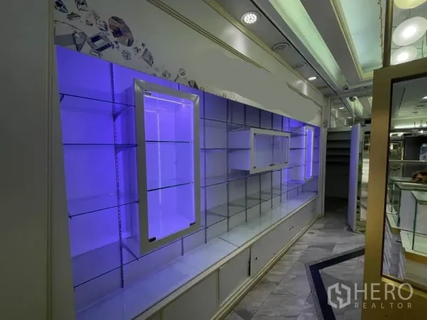 Shophouse for rent in Bang Rak, Bangkok - Backlit glass shelving with purple LED lighting for product displays.
