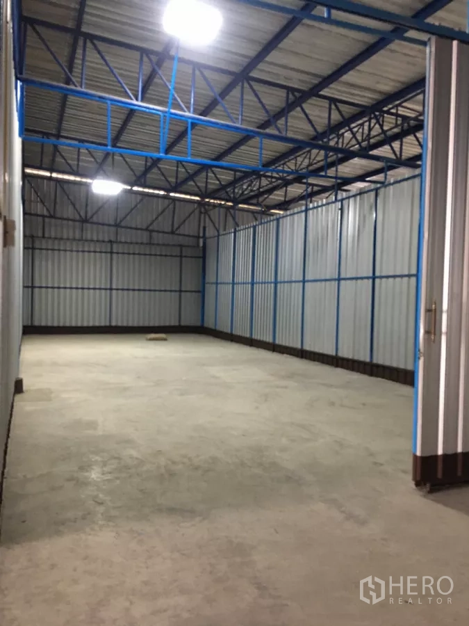 Warehouse for rent in Bueng Kum, Bangkok - Long storage bay with steel-frame roof, bright lighting, and durable concrete flooring.