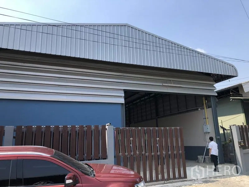 คลังสินค้า ขายในPathum Thani - ด้านหน้าโกดังผนังเมทัลชีท หลังคาทรงจั่วสูง พร้อมรั้วเลื่อนสีน้ำตาลในคลองหลวง