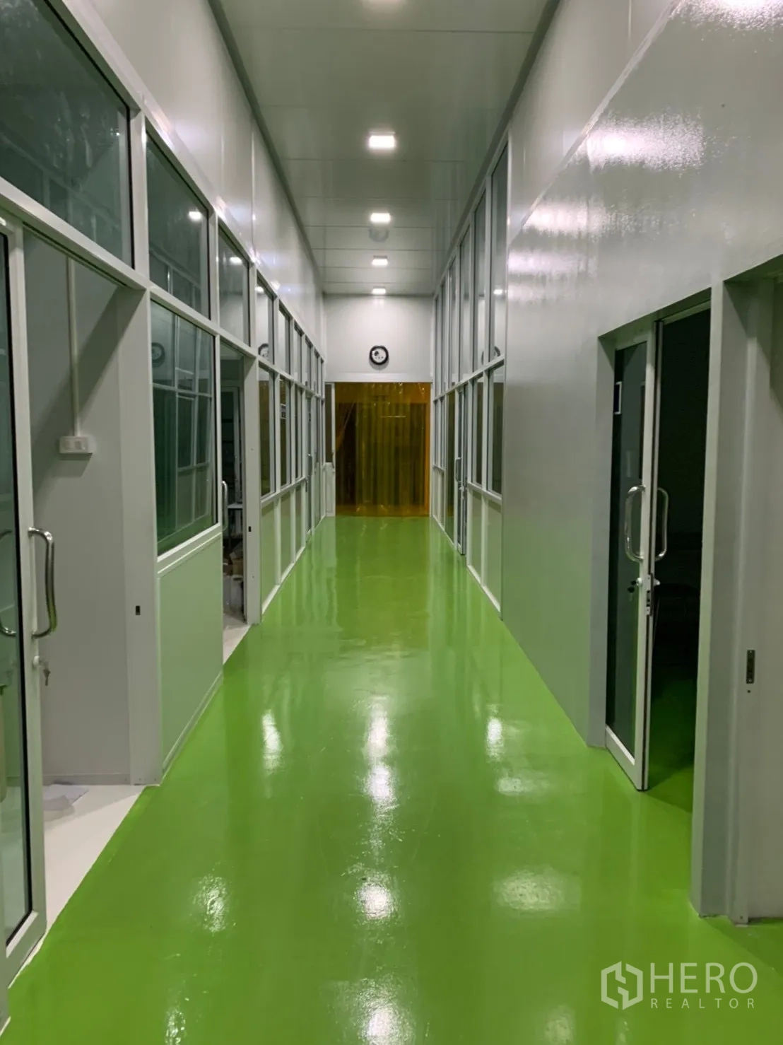 Factory for rent in Khlong Luang, Pathum Thani - Long hallway of the clean zone with glass doors and bright lighting.