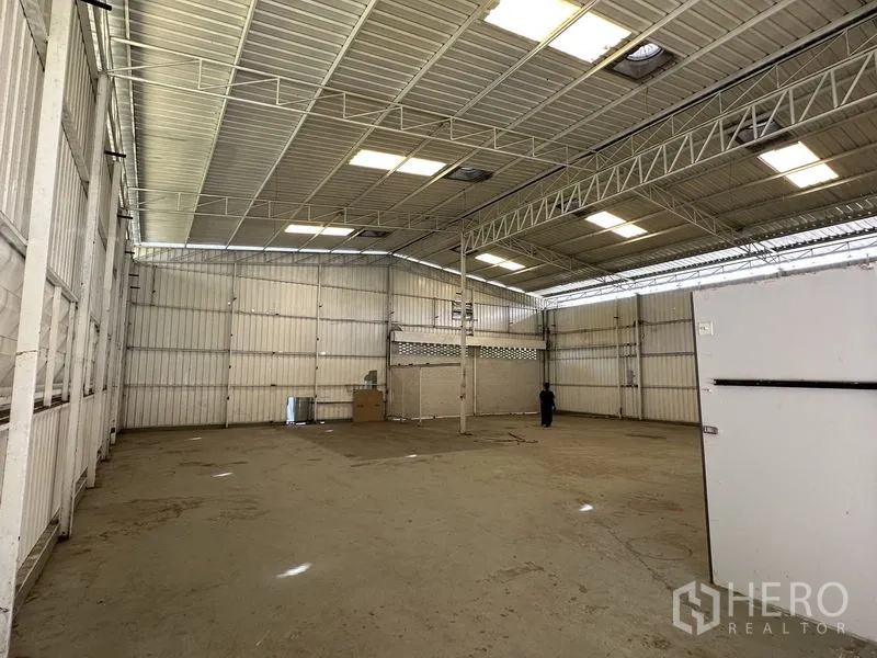 Warehouse for rent in Min Buri, Bangkok - High-ceiling warehouse interior with steel trusses, skylights, and an open clear-span floor.