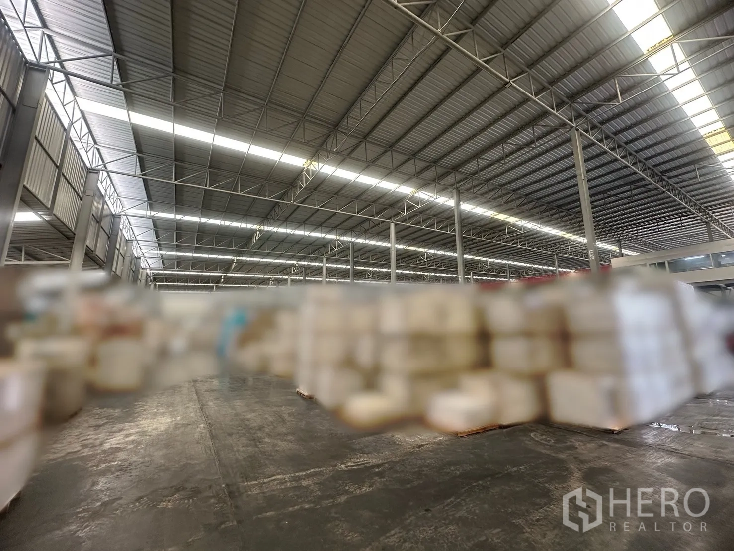 Warehouse for rent in Bang Yai, Nonthaburi - Steel truss roof with skylight strips above the storage area inside the warehouse.