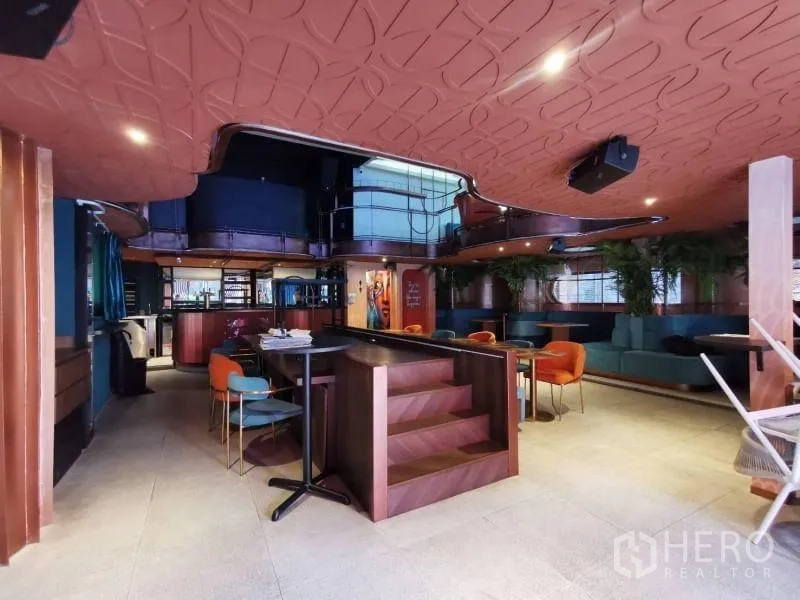 Retail Space for rent - Open-plan retail floor with patterned ceiling, central steps, and a bar counter.