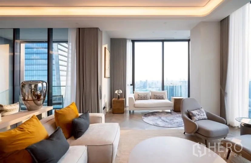 Condominium for rent or sale in Pathum Wan, Bangkok - Corner lounge with curved seating, cove lighting and panoramic floor-to-ceiling windows.