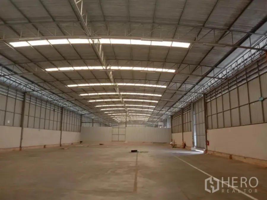 Warehouse for rent in Lat Krabang, Bangkok - Spacious warehouse interior with high steel truss roof, skylight panels and smooth concrete floor.