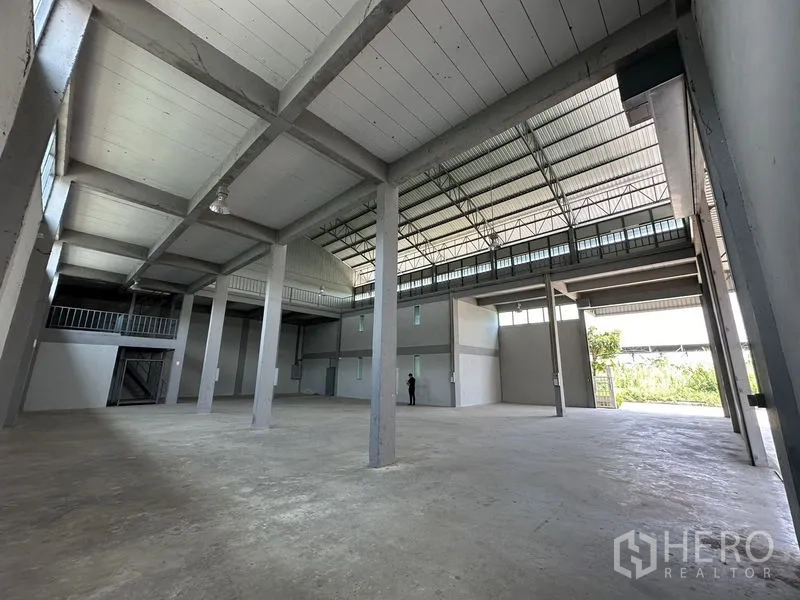 Factory for rent in Lam Luk Ka, Pathum Thani - Open-plan warehouse space with multiple pillars and natural light from high windows.