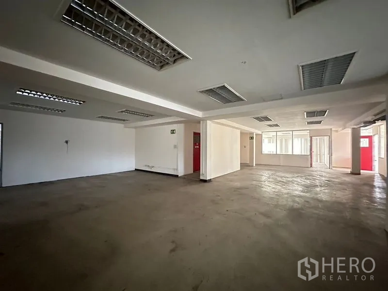货栈 出租在Suan Luang, Bangkok - 开放办公楼层，可见红色房门与多扇窗户。
