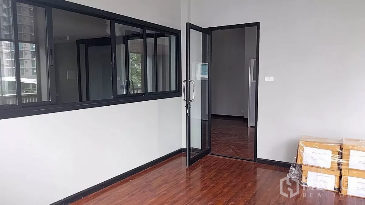 Retail Space for rent - Office-style room with sliding windows, a glass door and wood floors with boxes stacked.