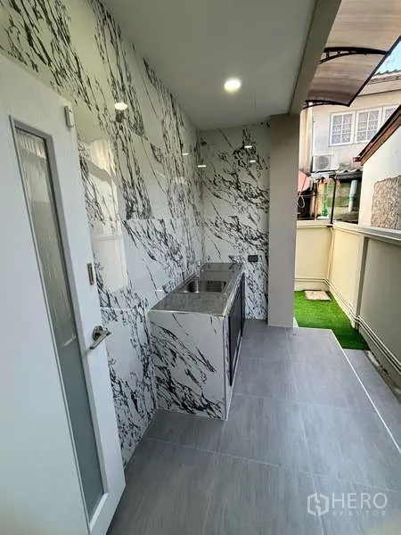 Detached House for rent or sale in Suan Luang, Bangkok - Covered outdoor wet kitchen with sink and marble-pattern wall tiles