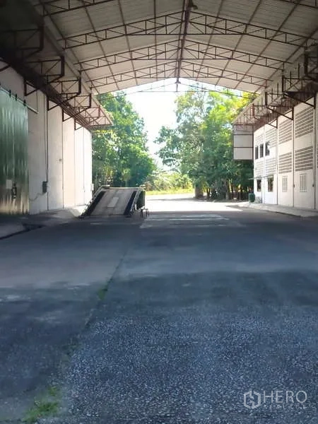 Warehouse for rent in Mueang Rayong, Rayong - Loading zone with a raised truck ramp under a large steel canopy.