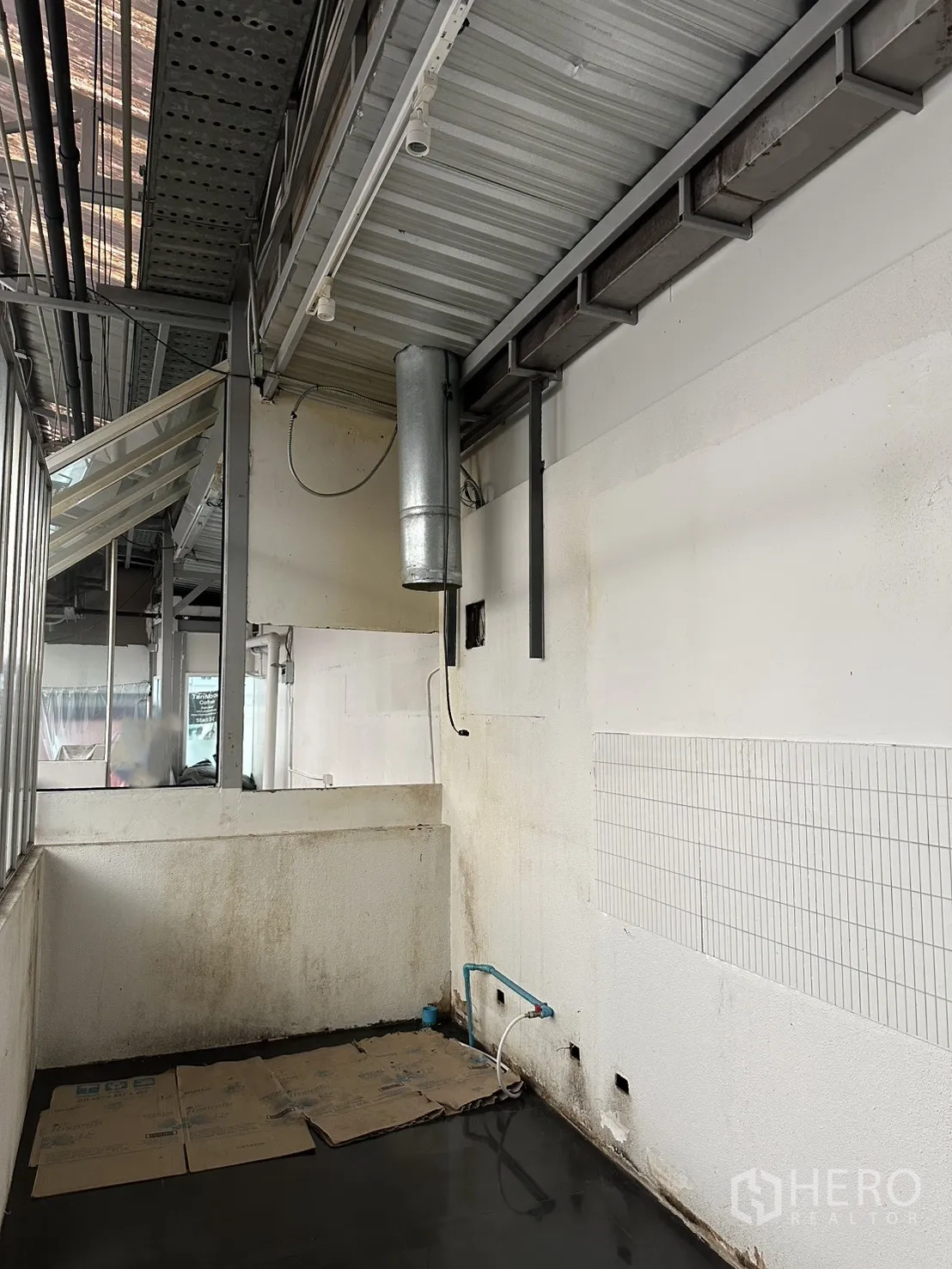 Retail Space for rent in Bang Rak, Bangkok - Rear service area showing a plumbing point, ventilation duct and dark tile flooring.