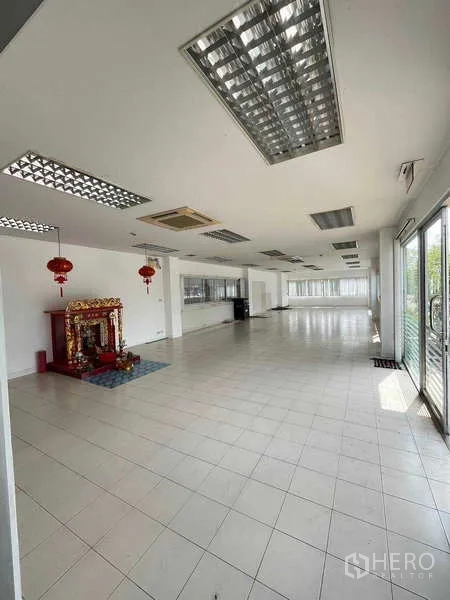 Warehouse for rent in Lat Krabang, Bangkok - Large open-plan office with tiled floors, ceiling lights and sliding glass doors.