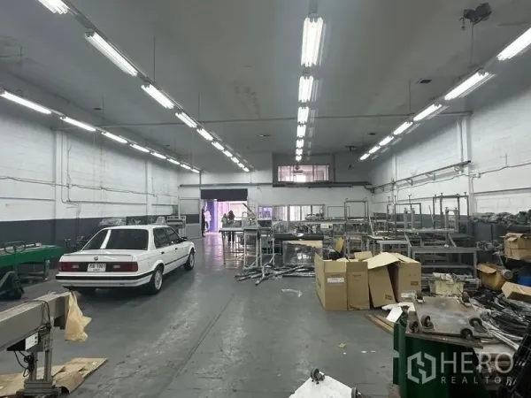 工厂 出租或出售在Khlong Luang, Pathum Thani - 车间内部，可见设备流水线、储物架和夹层办公室窗户。