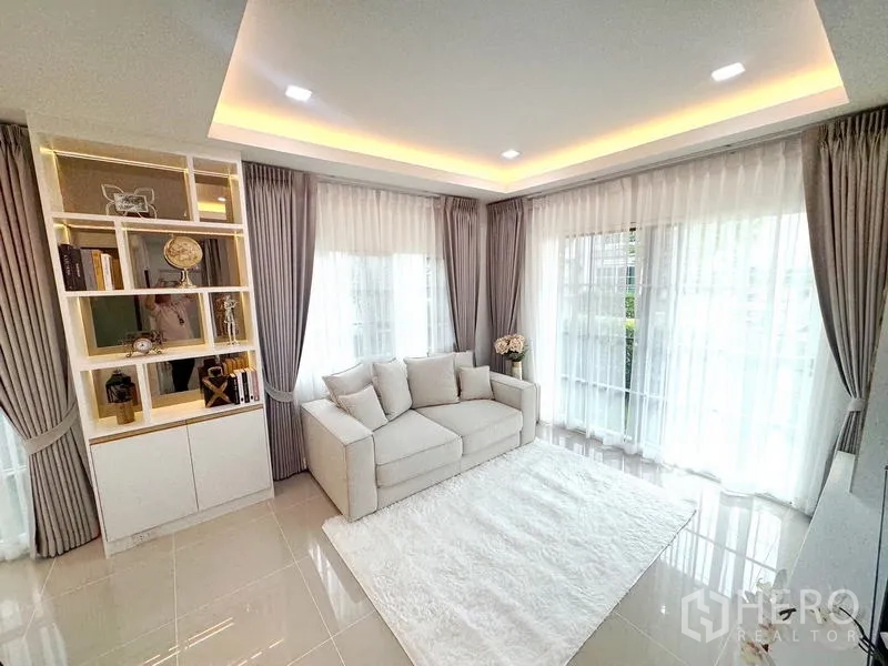 Detached House for rent - Bright living room with sofa, white rug and wraparound windows.