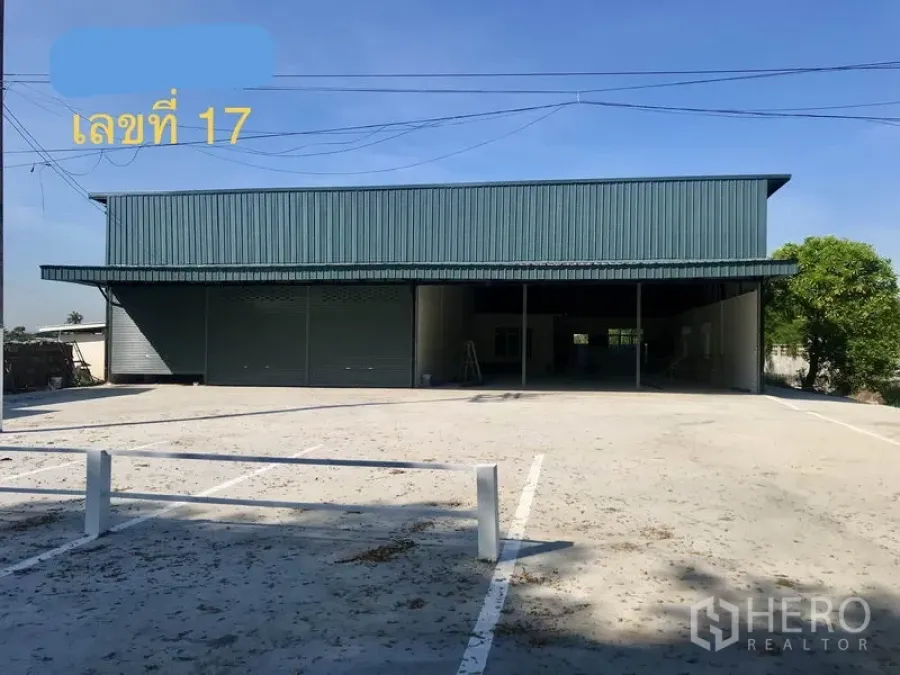 Warehouse for rent in Lam Luk Ka, Pathum Thani - Front view of brand‑new metal‑clad warehouse with wide concrete yard and twin roller shutters in Lam Luk Ka, Pathum Thani.