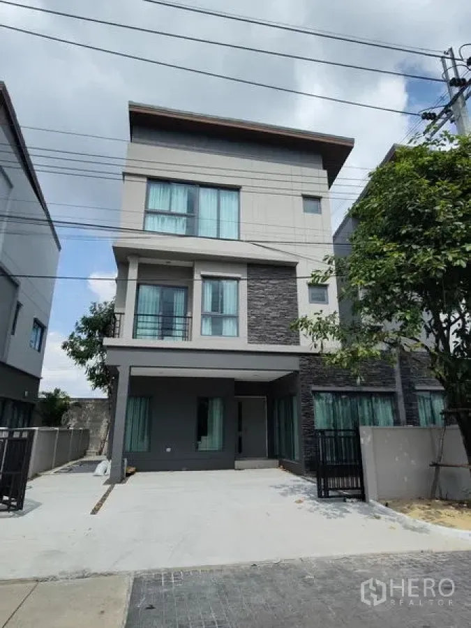 บ้าน ให้เช่าในSaphan Sung, Bangkok - ภายนอกบ้านเดี่ยวสไตล์โมเดิร์นสูงสามชั้น มีโรงจอดรถและระเบียง
