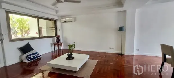 Townhouse for rent in Sathon, Bangkok - Minimalist living space with low coffee table, air conditioning and a large window.