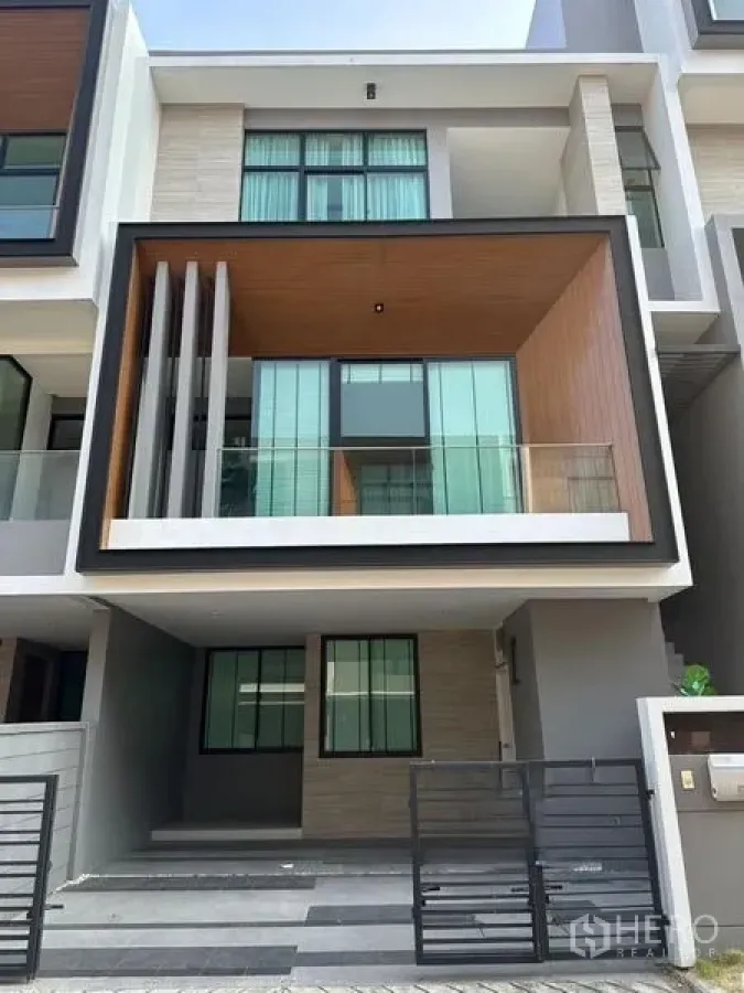 Townhouse for sale in Saphan Sung, Bangkok - Street-facing view of the contemporary townhouse exterior with carport and balcony.