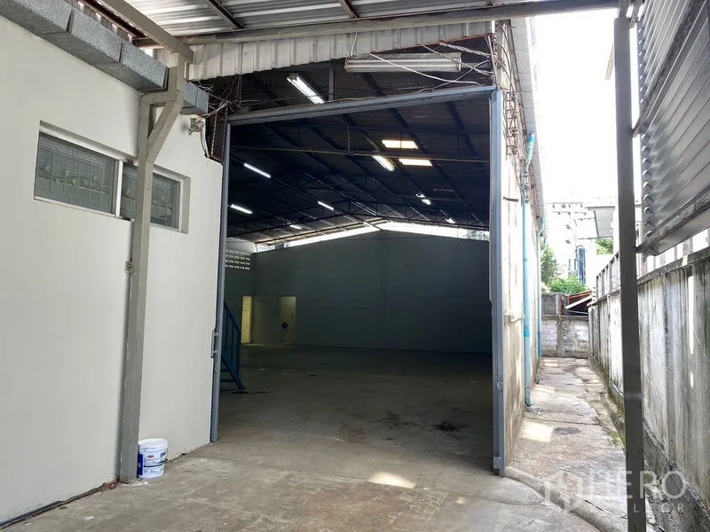 货栈 出租在Chatuchak, Bangkok - 宽敞入口通向深进的仓储大厅，混凝土地面与天窗。