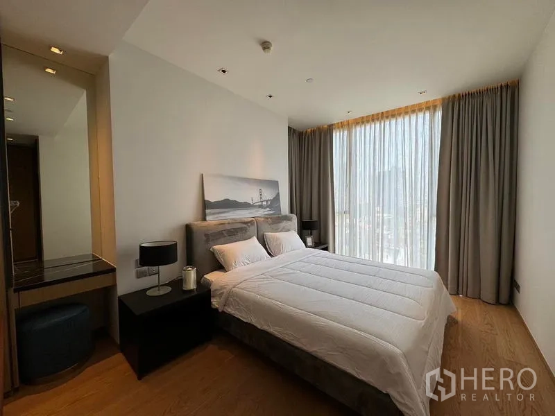 Condominium for rent - Master bedroom with king bed, bedside tables, and full-height windows with drapes.