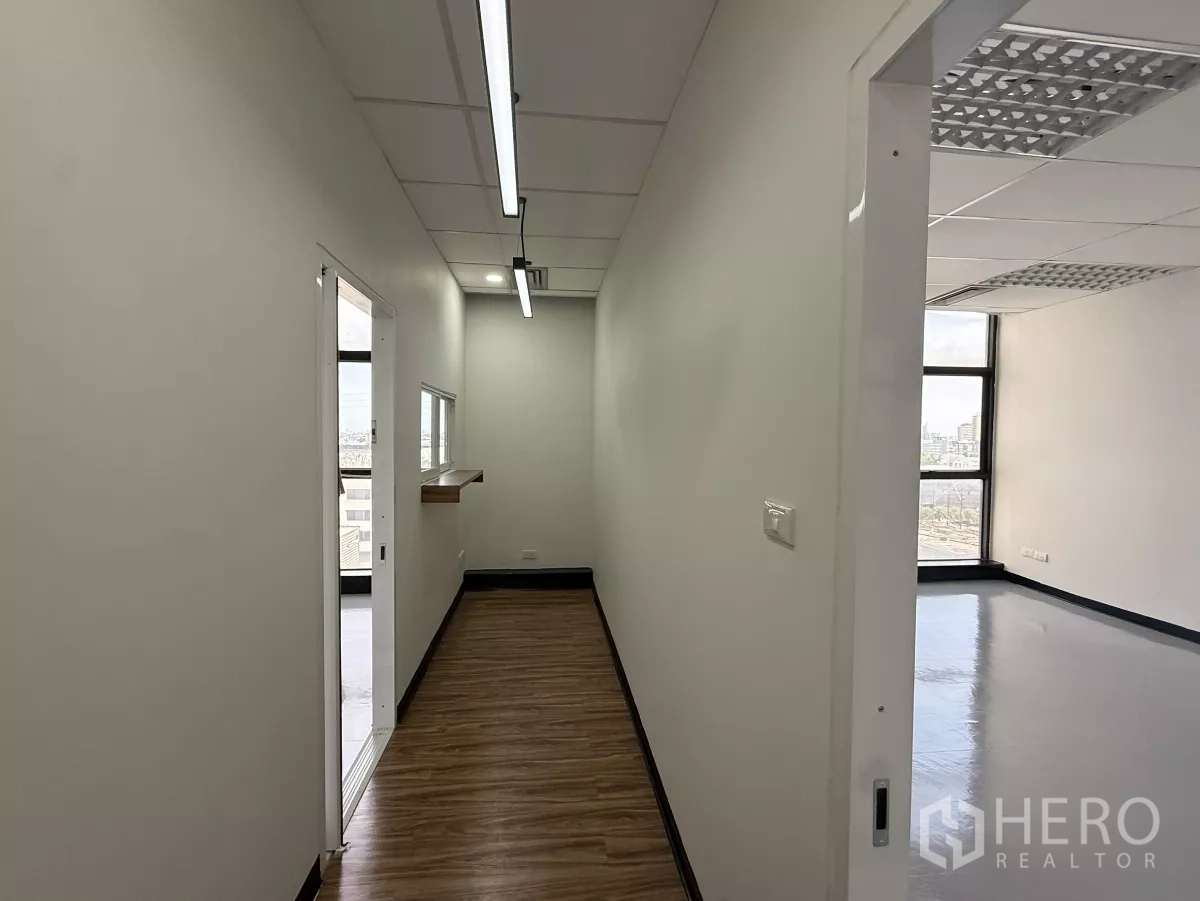 Office Space for rent - Bright corridor with windows, sliding doors to rooms and wood-look flooring.