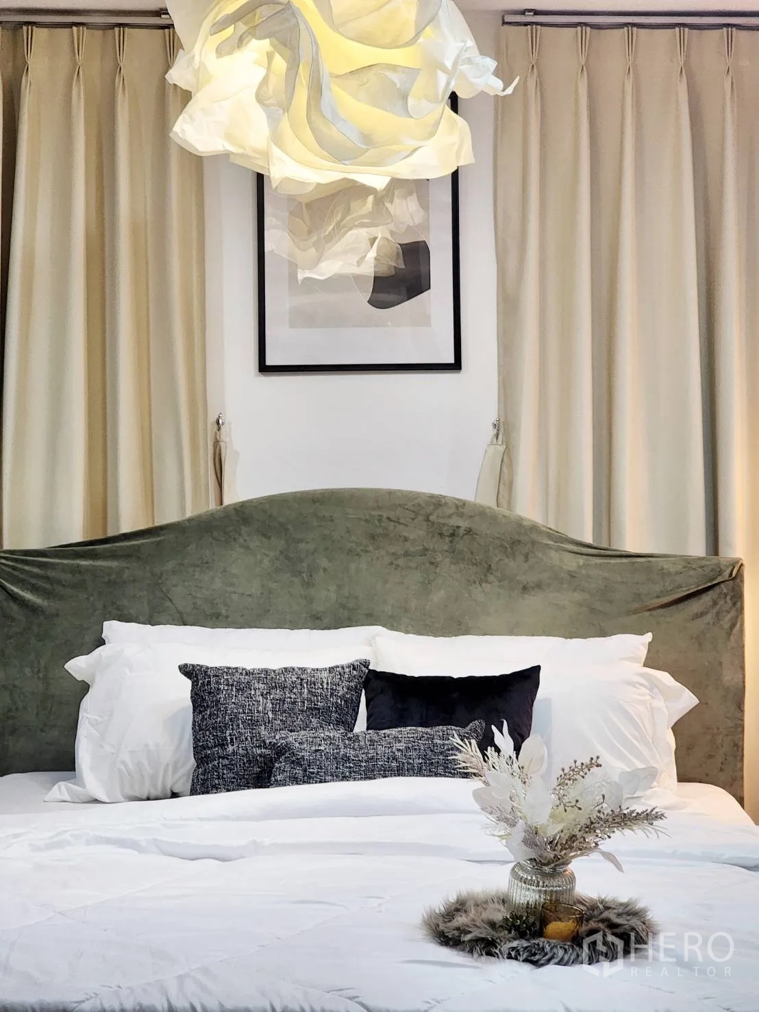 Detached House for rent in Huai Khwang, Bangkok - Bedroom featuring a green upholstered headboard, sculptural pendant, and layered pillows.