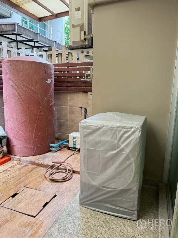 Townhouse for rent in Suan Luang, Bangkok - Utility area with large water tank, pump and washing machine.