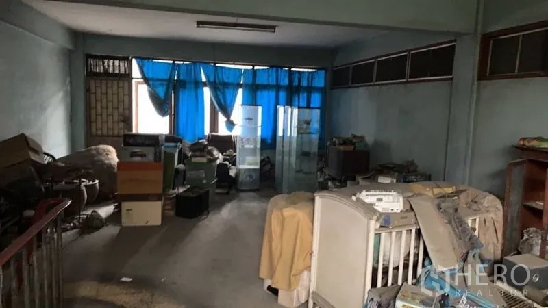 Shophouse for sale in Khlong Toei, Bangkok - Upper floor storage room with windows and ample space for office conversion.
