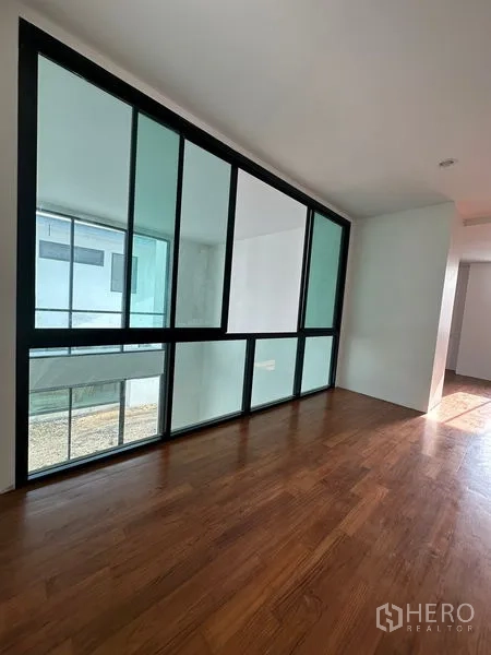 Detached House for rent in Watthana, Bangkok - Room with a wide internal glass wall overlooking the courtyard and lower living space.