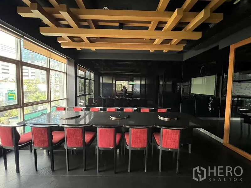 Shophouse for rent or sale in Khlong Toei, Bangkok - Meeting or dining space with decorative timber grid ceiling and large table.