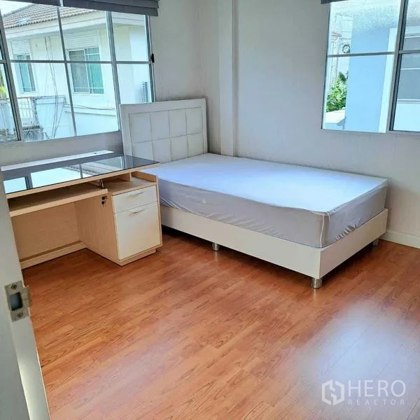 Detached House for rent in Prawet, Bangkok - Secondary bedroom with single bed, study desk and large corner windows.