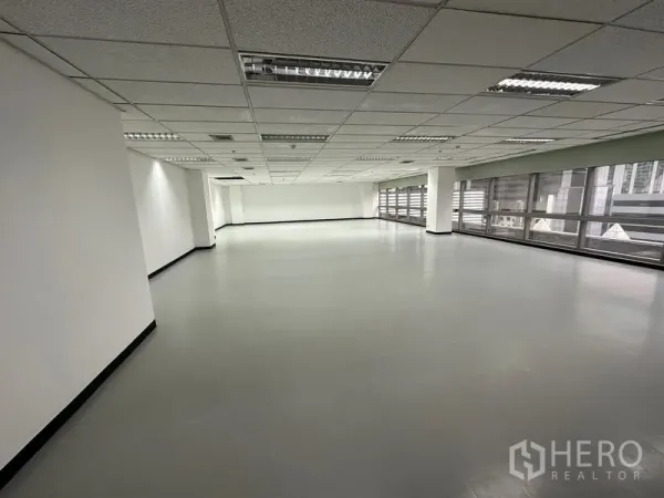 Office Space for rent - Large open office area with smooth vinyl flooring and panoramic windows on two sides.