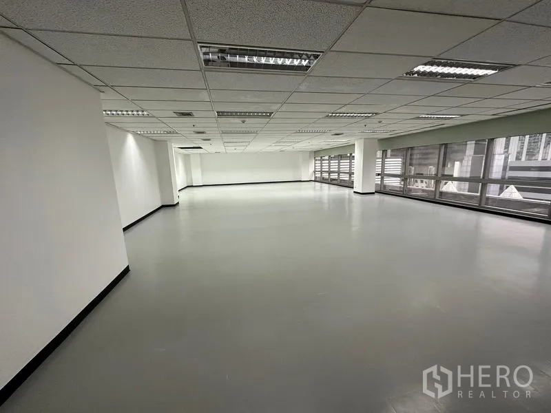 Office Space for rent - Large open office area with smooth vinyl flooring and panoramic windows on two sides.