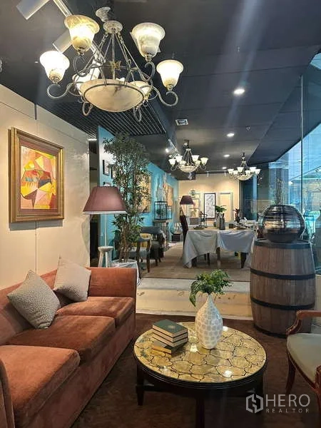 Retail Space for rent - Cozy corner with sofa, round coffee table and chandeliers beside floor-to-ceiling glass.