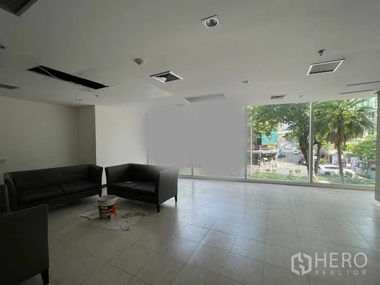 Retail Space for rent - Open-plan retail interior with tiled floors, floor-to-ceiling windows, and city street views.