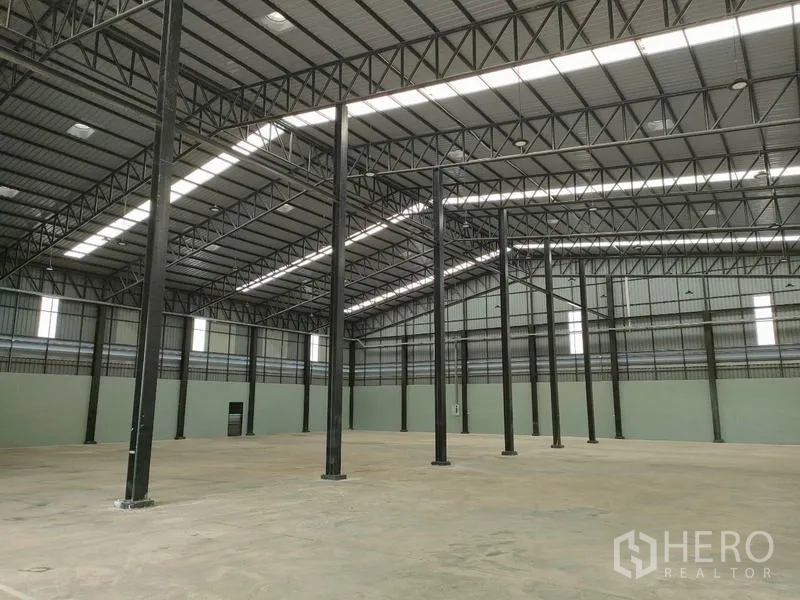 Factory for rent in Ban Phaeo, Samut Sakhon - Vast high-clear warehouse with steel columns and skylights.