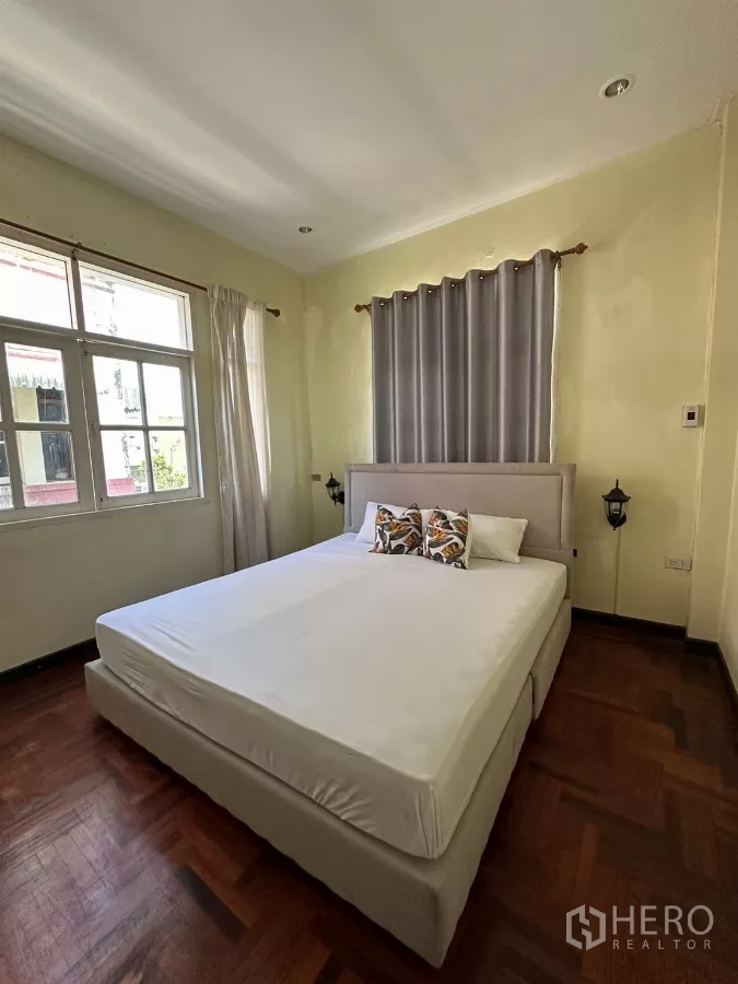 Home Office for rent in Suan Luang, Bangkok - Sunlit bedroom with upholstered bedframe and drapes.
