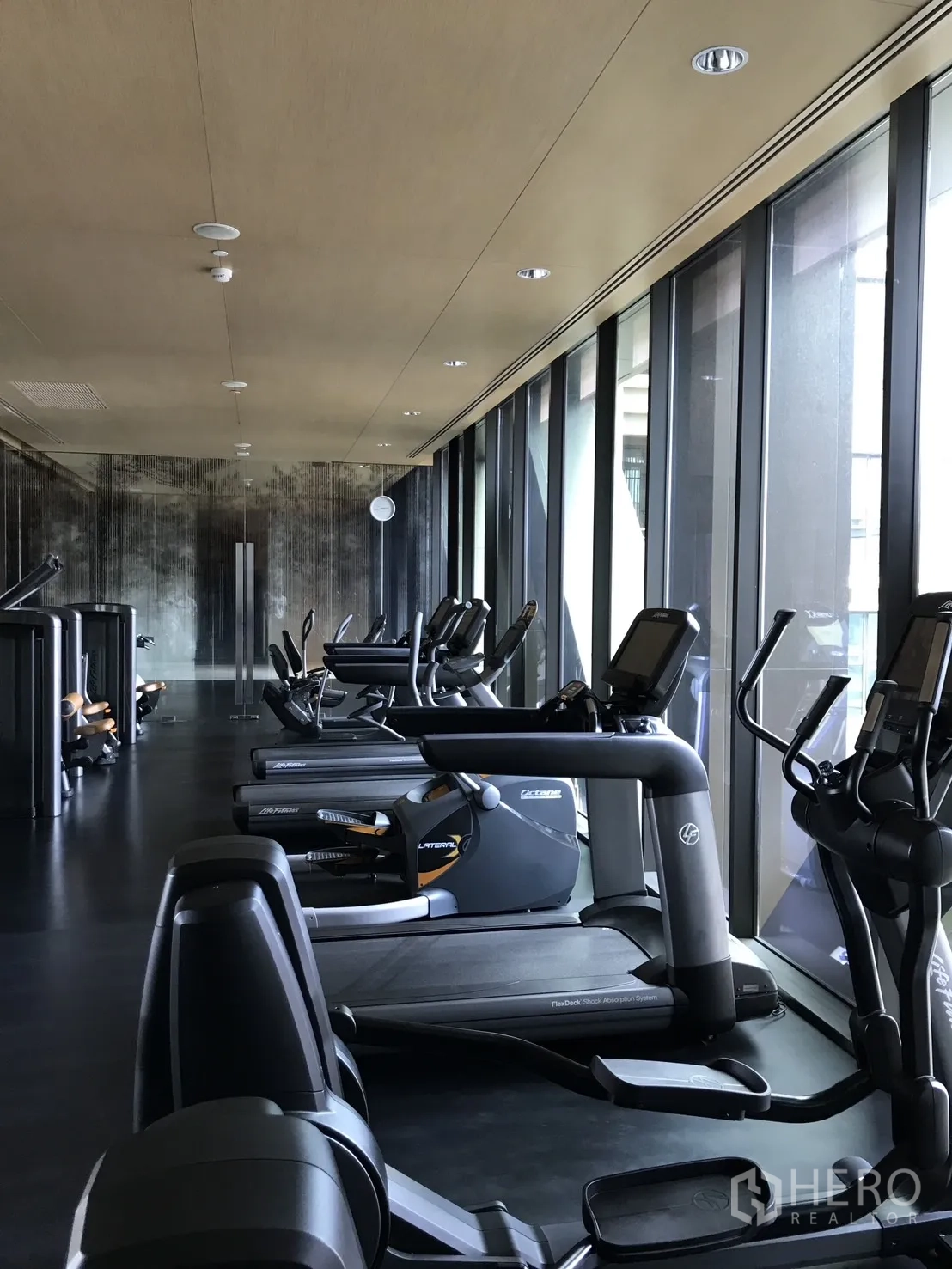Condominium for rent in Pathum Wan, Bangkok - Fitness center with treadmills and cardio machines alongside floor-to-ceiling windows.