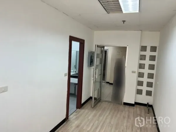 Office Space for rent in Pathum Wan, Bangkok - Small corridor with wood flooring, glass door entrance and access to the restroom.