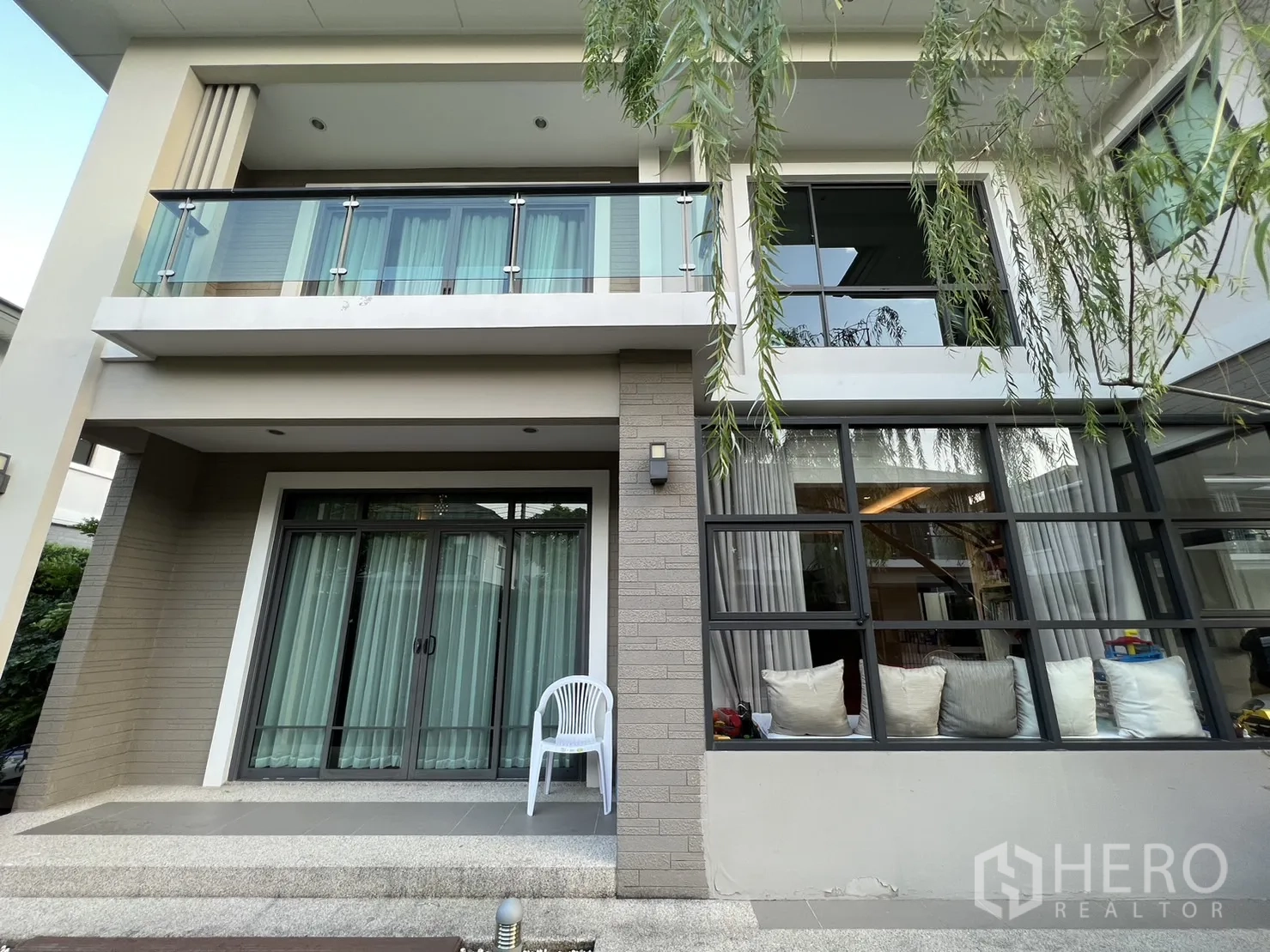 独立式住宅 出租在Suan Luang, Bangkok - 立面近景，玻璃阳台、推拉门与落地窗。
