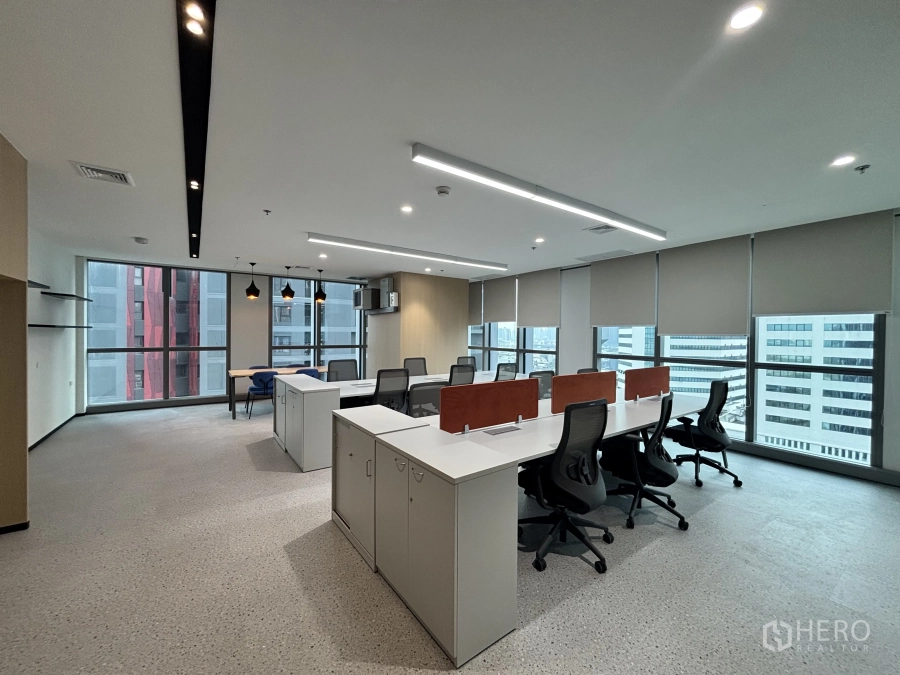 Office Space for rent in Huai Khwang, Bangkok - Open-plan office with long workstations, ergonomic chairs, built-in storage and floor-to-ceiling windows with city views.