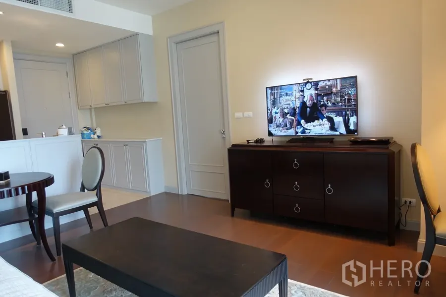 Condominium for sale in Pathum Wan, Bangkok - Bright living area with TV console, built-in cabinets, and warm wood floors.
