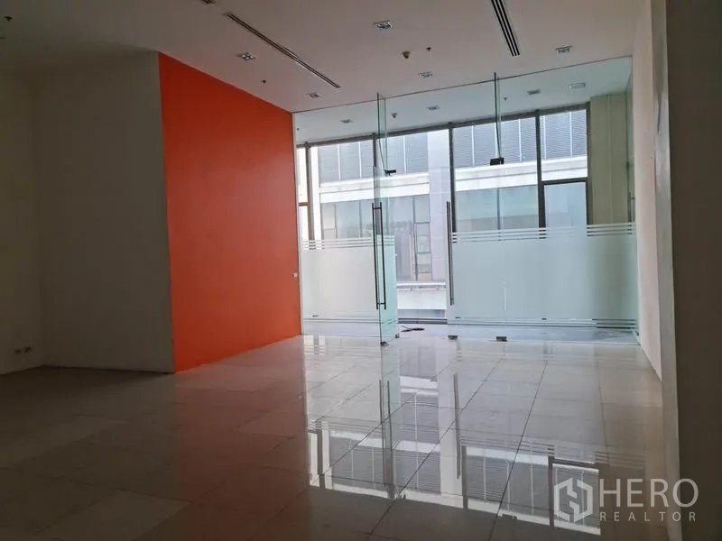 Retail Space for rent in Khlong Toei, Bangkok - Retail area facing full-height glass facade with frosted panels and orange wall.