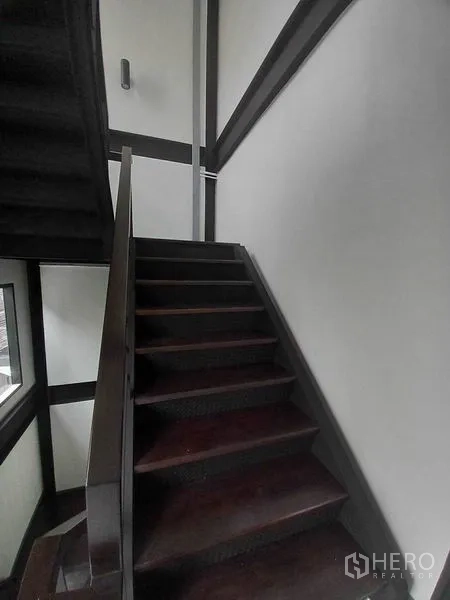 Retail Space for rent in Khlong Toei, Bangkok - Stair landing with metal rails, wall sconce, white walls and dark steps.