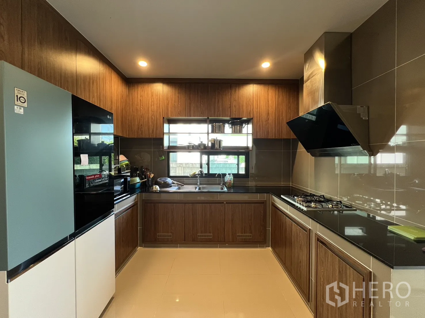 Detached House for rent or sale in Mueang Pathum Thani, Pathum Thani - Separate Thai kitchen with wood cabinetry, gas hob and extractor hood.