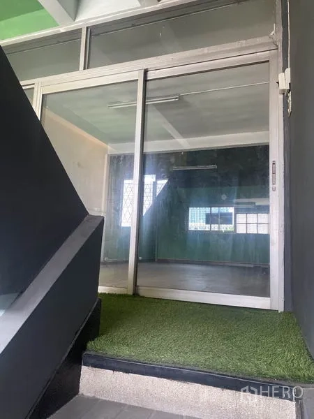Shophouse for rent in Watthana, Bangkok - Sliding glass door entry from the staircase with a small patch of artificial turf