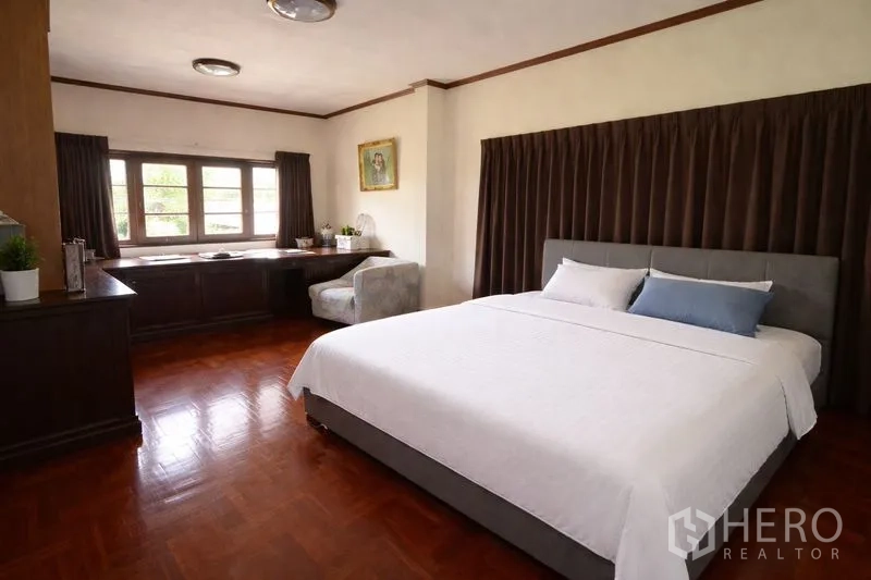 Detached House for sale in Suan Luang, Bangkok - Large bedroom with king bed, long work desk and wide windows.